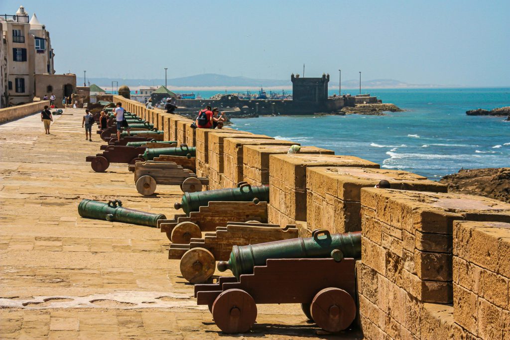 Cannons on a fortress wall facing the sea, capturing historical and coastal scenery.