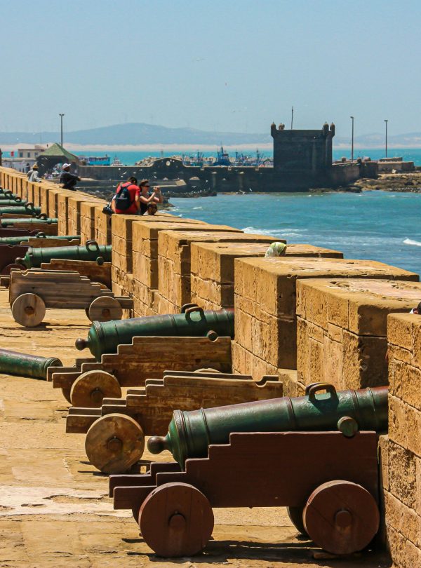 Cannons on a fortress wall facing the sea, capturing historical and coastal scenery.