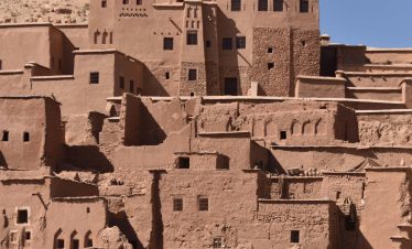 A stunning view of the historic mudbrick buildings of Aït-Ben-Haddou in Morocco under a clear blue sky.